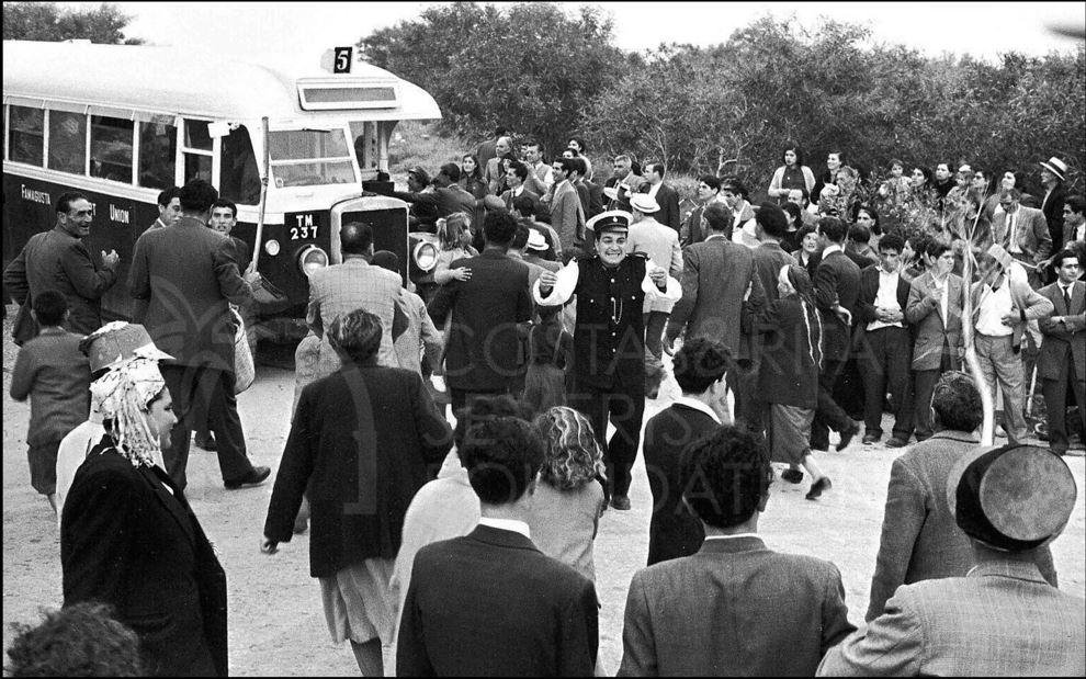 The policeman in the centre seems to be trying to "control" the crowd getting on the bus-pht_RC_046